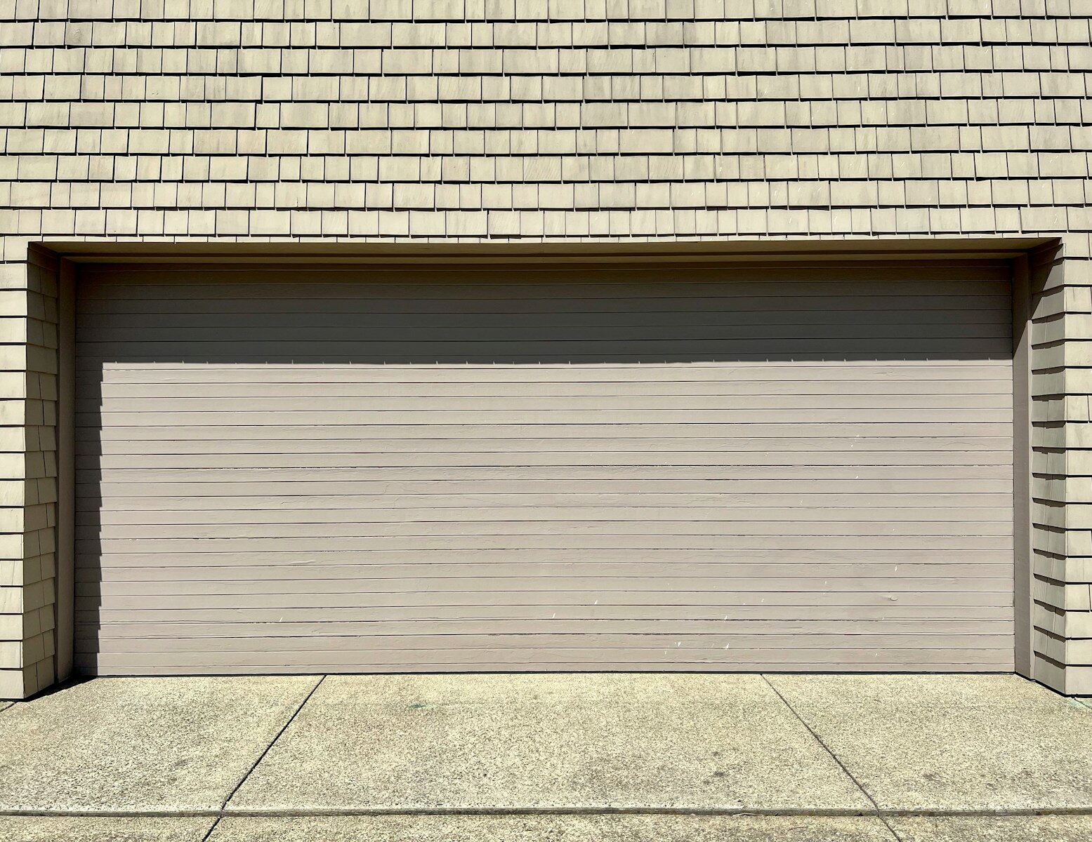 a white fire hydrant sitting in front of a garage door