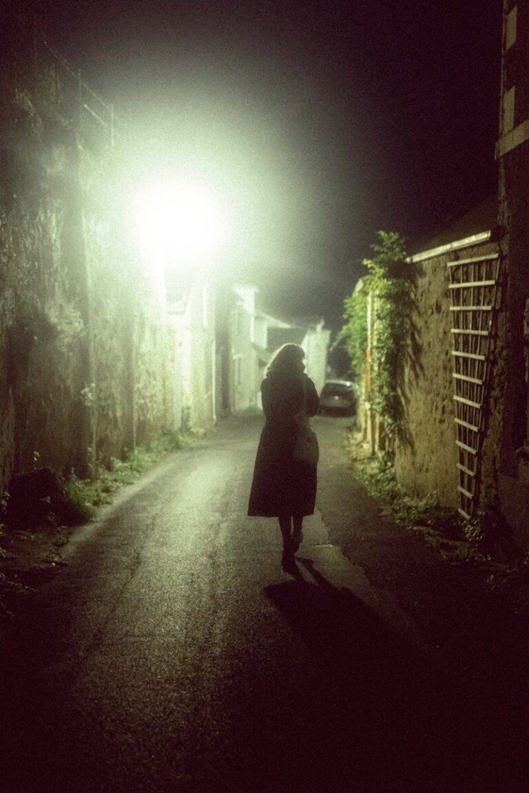 A person walking down a dark street at night