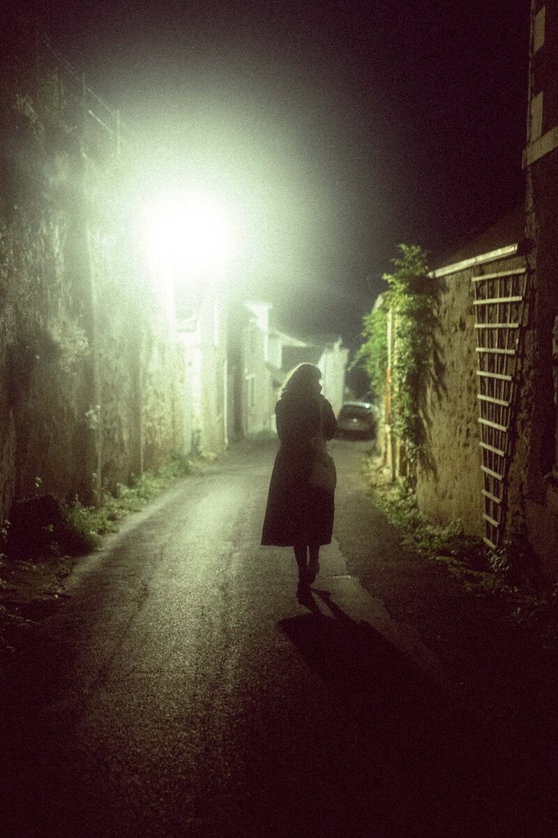 A person walking down a dark street at night