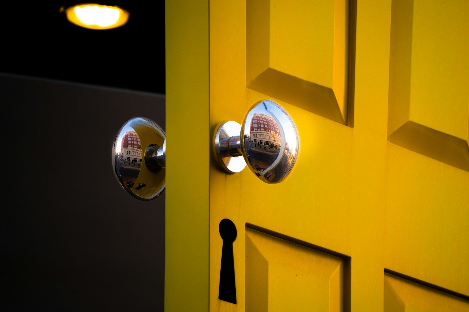 A bright yellow door with a silver doorknob.